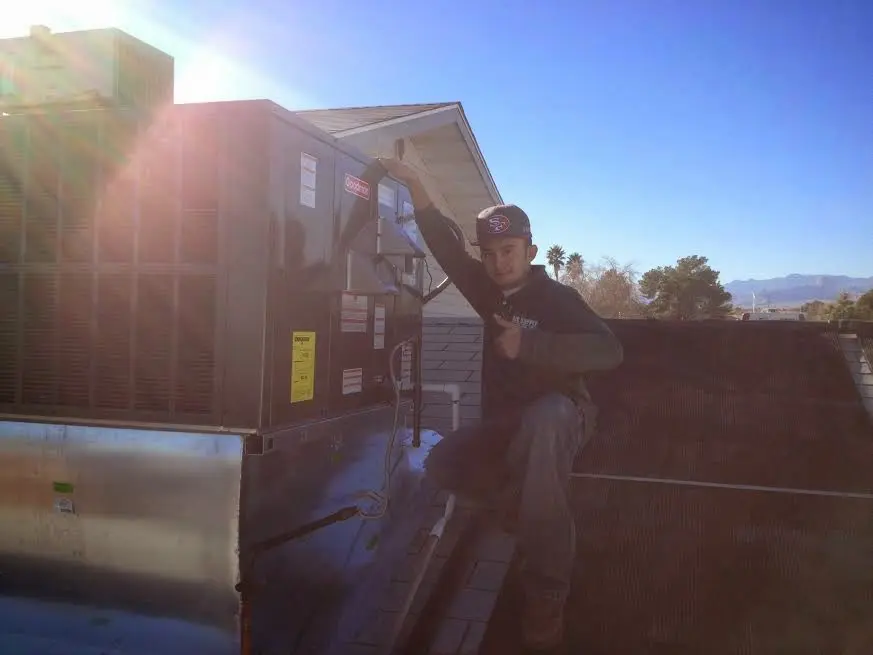 HVAC technician performing Boiler Repair on a rooftop unit in Savoy